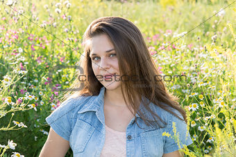 Portrait of girl of 16 years in flower meadow