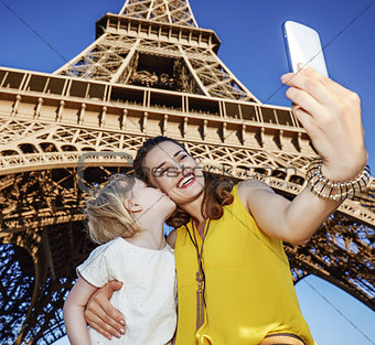mother and daughter tourists taking selfie near Eiffel tower