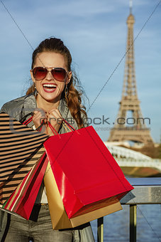 cheerful elegant woman with shopping bags near Eiffel tower