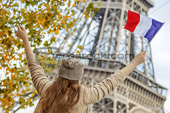 elegant woman on embankment in Paris, France rising flag