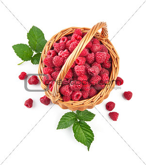 Fresh raspberries in wicker basket with green leaves