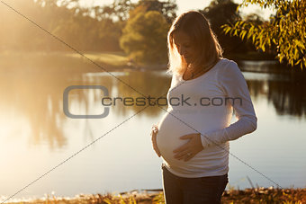 Beautiful pregnant woman at sunset