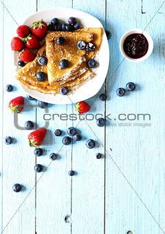 Delicious Crepes Breakfast with Dramatic light over a wood background