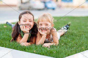 Two little sisters having fun in summer park