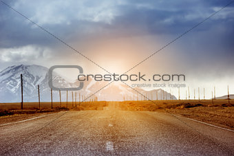 Straight road car concept. Mountains backdrop
