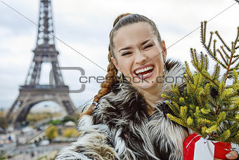smiling fashion-monger with Christmas tree taking selfie in Pari