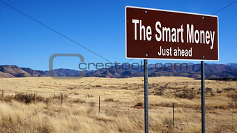 The Smart Money brown road sign