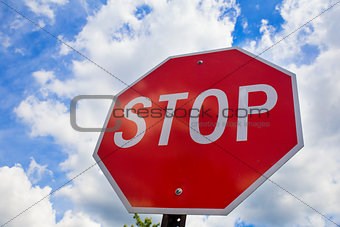 Red stop sign on the street, roadside traffic  for stopping.