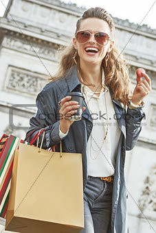 woman with shopping bags in Paris having coffee and macaroon
