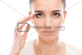 Young woman checking her face skin