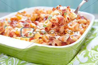 Pasta casserole with bacon, ham, cheese and tomato