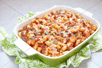 Pasta casserole with bacon, ham, cheese and tomato