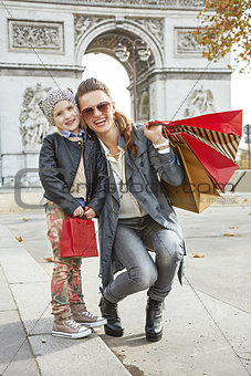 smiling mother and child with shopping bags in Paris, France