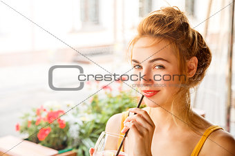 Young Woman Drinking Cocktail in a Cafe