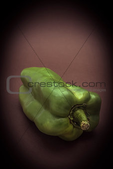 Green pepper isolated on a brown background