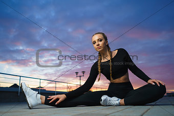Happy girl stretch outdoor at modern urban area during sunset