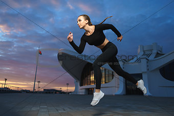 Happy girl run outdoor at modern urban area during sunset.