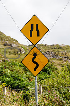Winding road and bottleneck signs