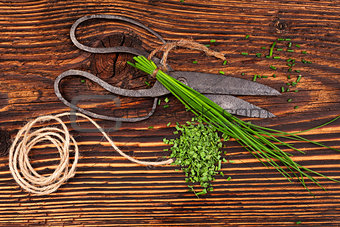 Fresh and dry chives on wooden table.