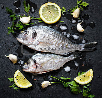 Fresh Fish Orata Over a Black stone with vegetables