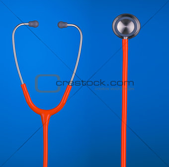 Orange stethoscope headset and bell closeup isolated on blue bac