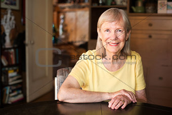 Confident mature woman seated at table