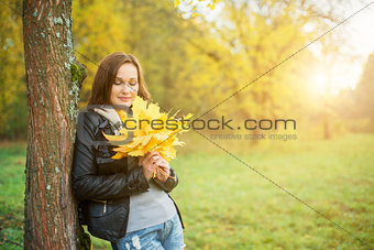 Young woman holding yellow leaf