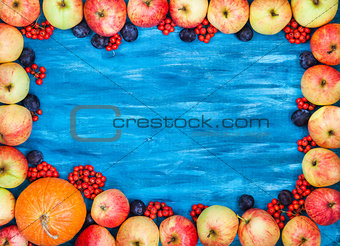 Autumn frame of apples, pumpkin, rowan on  painted blue wooden b