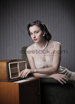 Sensual woman listening music on old radio