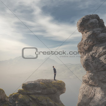 Young businessman standing on edge of rock mountain 