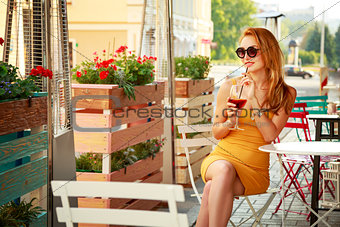 Young Fashion Woman Drinking Cocktail in a Cafe