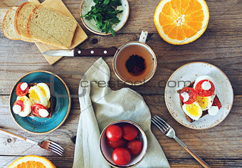 Breakfast table set with sandwiches, fruits and tea