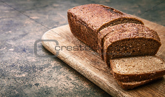 Fresh bread cut on wooden board