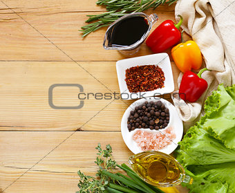 herbs and spices, vegetables and sauces on wooden background