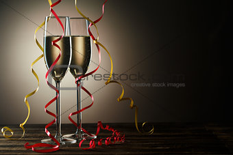 Two champagne glasses with decorative yellow and red ribbons
