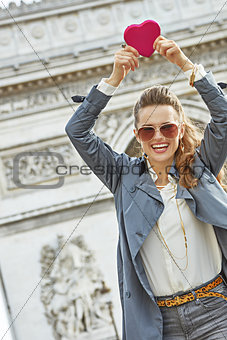 trendy woman near Arc de Triomphe showing red heart