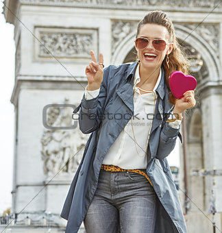 happy young fashion-monger in Paris, France showing red heart