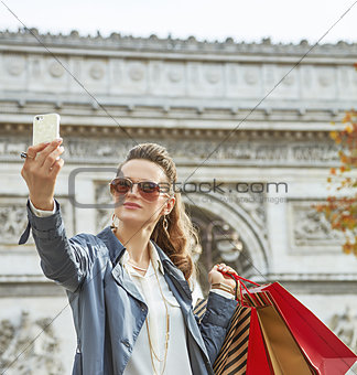 young woman shopper in Paris, France taking selfie with phone