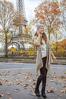 happy young woman in Paris, France using mobile phone