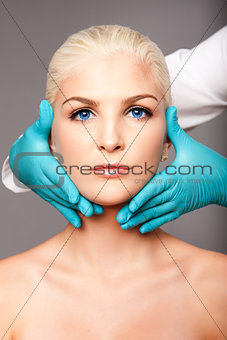 Cosmetic plastic surgeon touching aesthetics face