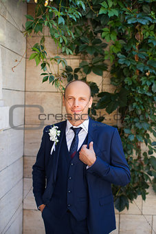 The groom in a blue suit with  vest