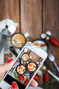 Taking food photo of breakfast with fried eggs by smart phone