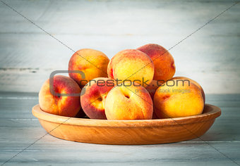 Fresh peach on wooden plate and board