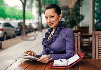 Business woman at the street coffe shop with her tablet