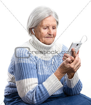 Senior woman listening to music or watching video on smartphone