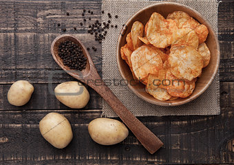 Bowl with potato crisps chips with pepper on wood