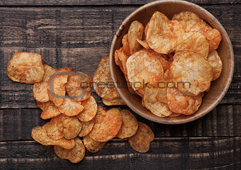 Bowl with potato crisps chips on wooden board