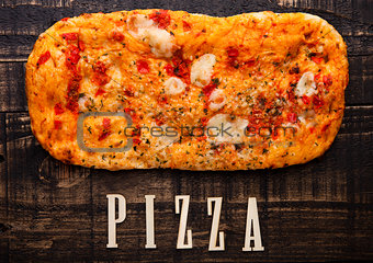 Pizza bread with tomatoes and mozzarella on wooden table