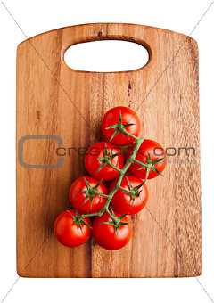 Fresh organic tomatoes on wooden board isolated on white background