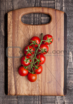 Fresh healthy organic tomatoes on wooden kitchen board